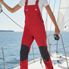 Person wearing red and black overalls on a sailboat with blue water and sky in the background