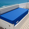 Blue cushioned bench on a boat deck with ocean view
