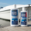 Two bottles of Clear Plastic Polish and Restorer by Clair Brite on a dock with a boat in the background.