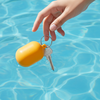 Hand holding a yellow keychain with keys over clear blue water