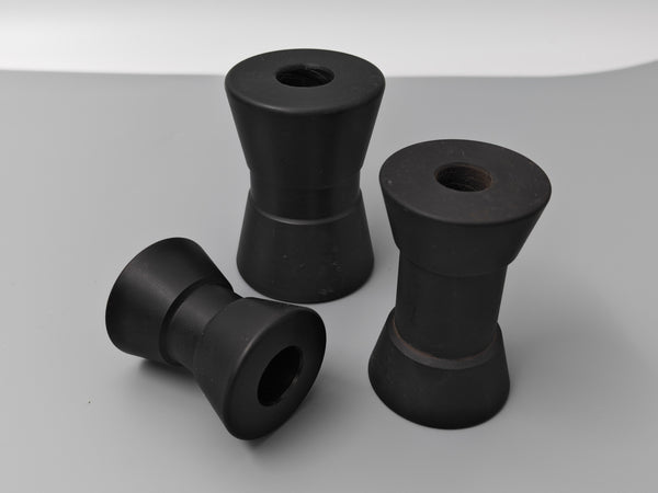 Three black trailer bushings on a gray background