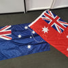 Two Australian flags on a gray floor with white cabinets in the background