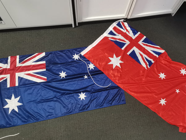 Two Australian flags on a gray floor with white cabinets in the background