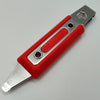 Red and silver utility knife on a gray background