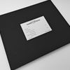 A black hardcover notebook or log book with a white paper label reading 'SANNOX LOG BOOK' on a plain white surface.