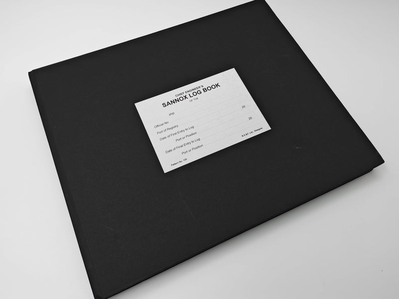 A black hardcover notebook or log book with a white paper label reading 'SANNOX LOG BOOK' on a plain white surface.