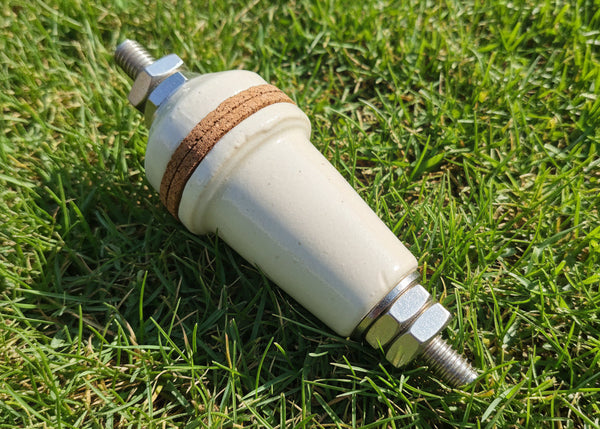 A ceramic automotive spark plug with a white insulator body, a brown leather washer, and silver metal electrodes, shown on a plain white background.