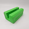 A bright green 3D-printed U-shaped block with a textured, layered appearance, shown on a neutral light gray background.