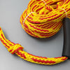Yellow and red rope with a black handle on a gray background