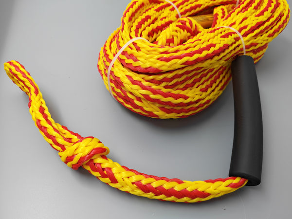 Yellow and red rope with a black handle on a gray background