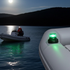 Inflatable boat with green light on a body of water at night