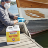 Person working on a boat with Norski Acetone container nearby