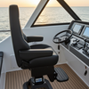 Yacht's driver's seat and dashboard with a view of the ocean during sunset.