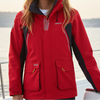 Woman wearing a red jacket on a boat with a scenic background