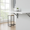 Wall-mounted white desk in a minimalistic room with a window and chair.