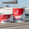 Two cans of Altex Epoxy paint on a dock with boats in the background
