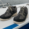 Pair of black and gray sneakers on a boat with water in the background