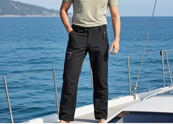 Man standing on a sailboat with ocean and sky in the background