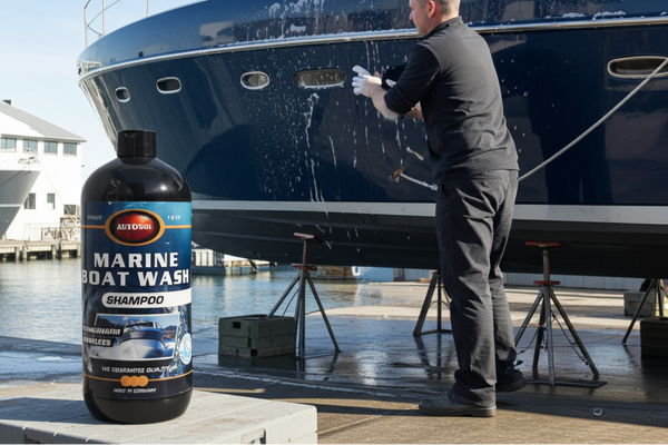 Person washing a boat with a bottle of Marine Boat Wash Shampoo in the foreground.