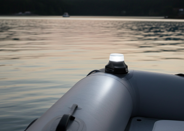 Inflatable boat on a lake with a light on during sunset