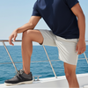 Man sitting on a boat with ocean and clear sky in the background