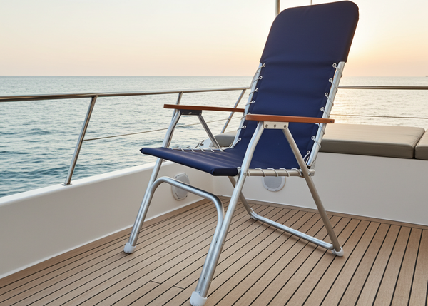 Blue lounge chair on a boat deck with ocean view