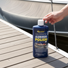 Person holding a bottle of CarPro Ultimate Aluminum Polish on a dock with a boat in the background.