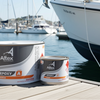 Two cans of Altex Epoxy paint on a dock with a boat in the background